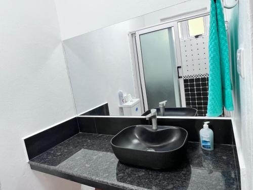 Poste LafayetteSunshine Residence的浴室设有黑色水槽和镜子