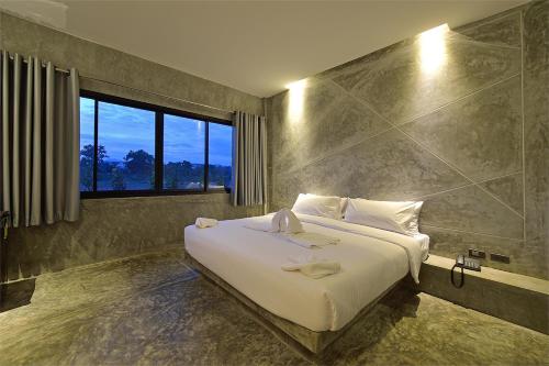 甲米镇绿洲度假村的卧室设有一张白色大床和一扇窗户。