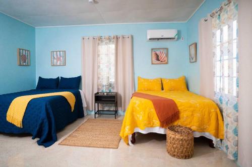 特雷热比奇Treasured Gem Hideaway的蓝色墙壁客房的两张床