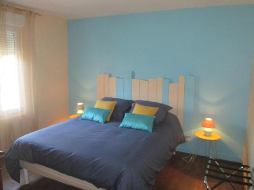 MolinetGîte Molinet, 3 pièces, 6 personnes - FR-1-489-253的一间卧室配有一张带蓝色墙壁的大床