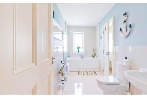BallyboughalModern Homestay Rooms Dublin Airport 15 minutes的白色的浴室设有浴缸和卫生间。