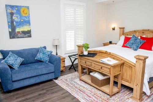 圣奥古斯丁Pomar House的一间卧室配有一张床和一张蓝色的沙发