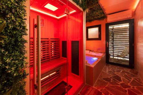 罗科福尔拉贝杜勒Minamina, chambre avec jacuzzi privatif的红色的浴室设有浴缸和水槽
