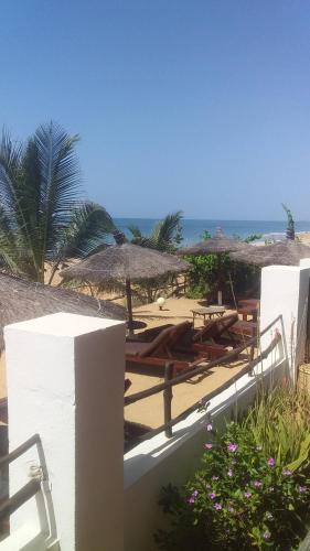 姆布尔Terra Lodge Sénégal的海滩上设有遮阳伞和椅子,还有大海