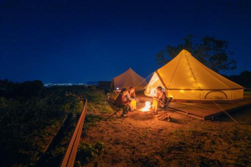 仓敷OKAYAMA GLAMPING SORANIA - Vacation STAY 73233v的一群人坐在帐篷前的火堆旁