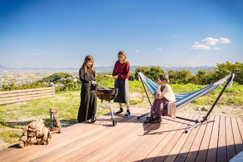 仓敷OKAYAMA GLAMPING SORANIA - Vacation STAY 20221v的一群站在带吊床的甲板上的女人