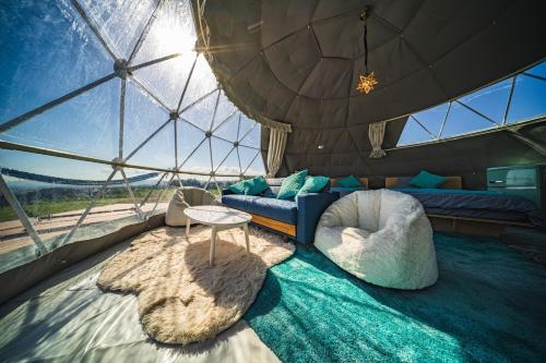 仓敷OKAYAMA GLAMPING SORANIA - Vacation STAY 20221v的圆顶内的房间,配有沙发和桌子
