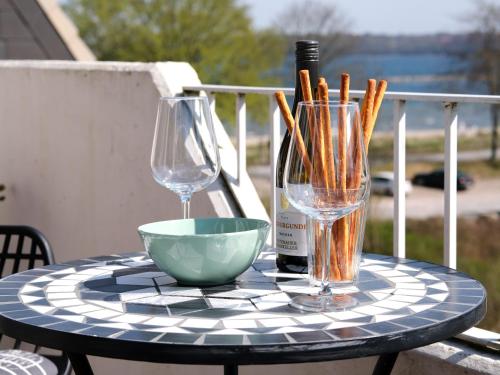 哈里斯莱Ostsee, wunderschöne Wohnung mit Meerblick的一张桌子,上面放着两杯,一个碗和一瓶葡萄酒