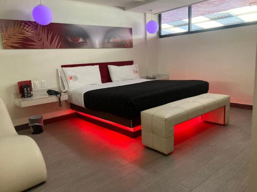 墨西哥城HOTEL HUIPULCO的一间卧室配有一张带红色LED照明的床