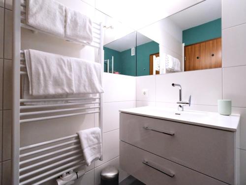 哈里斯莱Ostsee, wunderschöne Wohnung mit Meerblick的白色的浴室设有水槽和镜子