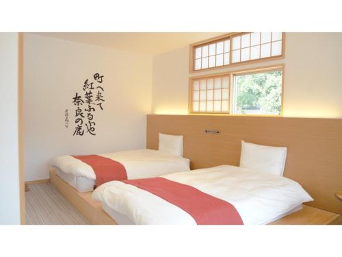 奈良Hotel Tenpyo Naramachi - Vacation STAY 59515v的带2扇窗户的客房内的2张床