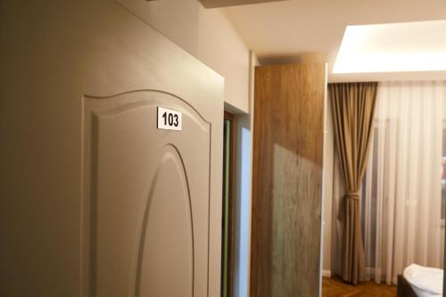 普里什蒂纳Amico Hotel的墙上有标志的门的房间