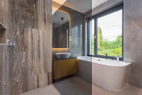 奥帕提亚Villa Titanium的浴室配有白色浴缸和水槽