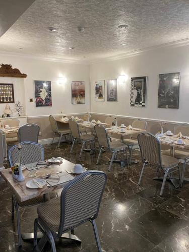 埃文河畔斯特拉特福克罗弗特宾馆的用餐室配有桌椅,墙上挂有图片