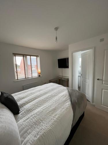 HatfieldHawk House - Furnished Accommodation的白色卧室设有一张大床和电视。