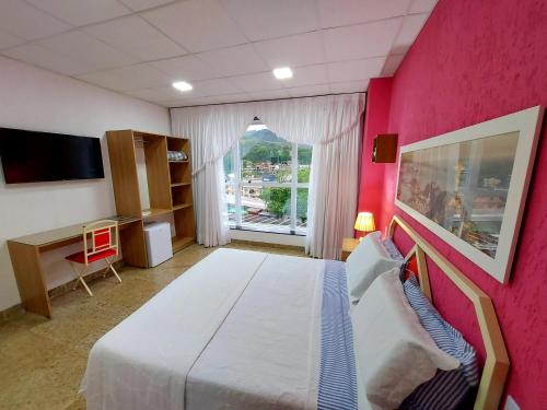 卡舒埃拉斯迪马卡库Hotel Netto的一间卧室设有一张大床和粉红色的墙壁