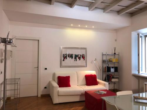 维杰瓦诺Emma Home adiacente alla Piazza Ducale的客厅配有白色沙发和红色枕头。
