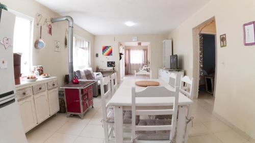 巴拉奈里奥-坎布里乌Casa Familiar Estaleiro的厨房配有白色的桌子和白色的椅子