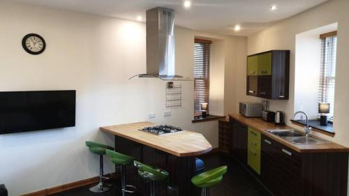 威克Ensuite Rooms的厨房配有水槽和带绿色凳子的台面