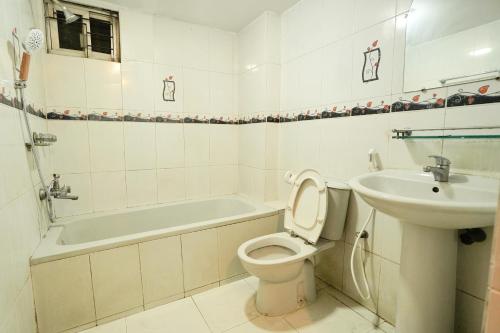 达卡Gulshan Lovely 3-Bedroom Luxury Apartment的浴室配有卫生间、盥洗盆和浴缸。