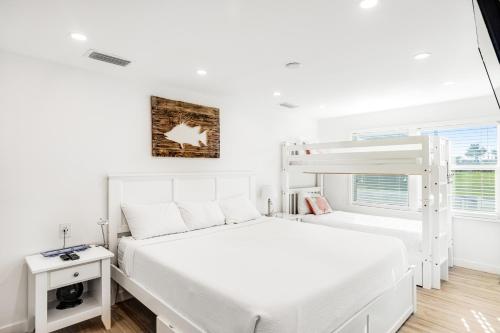 基克罗尼海滩A Wave From it All的白色的卧室设有双层床和窗户。
