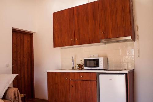 塞尔帕Horta das Laranjas的厨房配有木制橱柜和白色微波炉