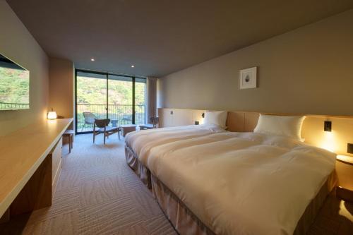 云仙市云仙宫崎旅馆 的一间卧室设有一张大床和一个大窗户
