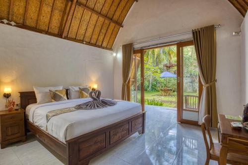 珀尼达岛Maharga Bungalows的一间卧室设有一张床,并有一扇通往花园的门