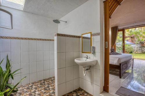 珀尼达岛Maharga Bungalows的一间带水槽和镜子的浴室以及一张床