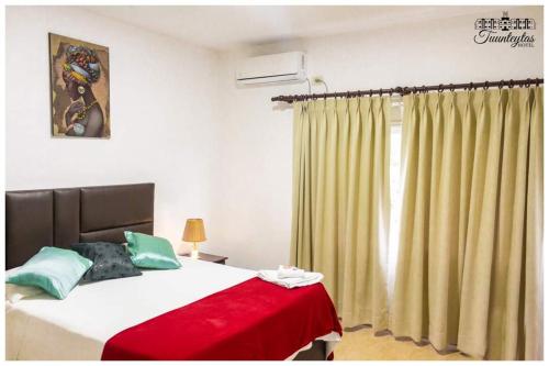 VillamontesHotel Tuunteytas的一间卧室配有一张带红色毯子的床和窗户。