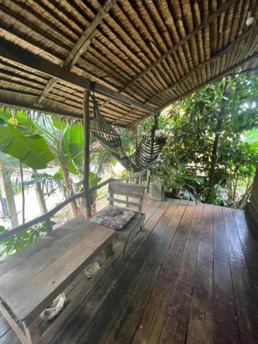象岛Happy Hippy House2的木制甲板配有长凳和吊床