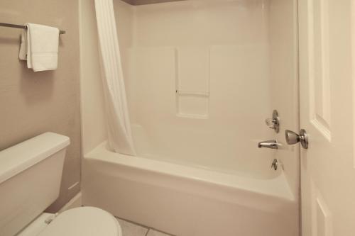 赛维尔维尔Mountain Aire Inn Sevierville - Pigeon Forge的浴室配有白色浴缸和卫生间。