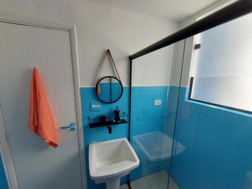 桑托斯Sala living na Av da Praia.的蓝色的浴室设有水槽和镜子
