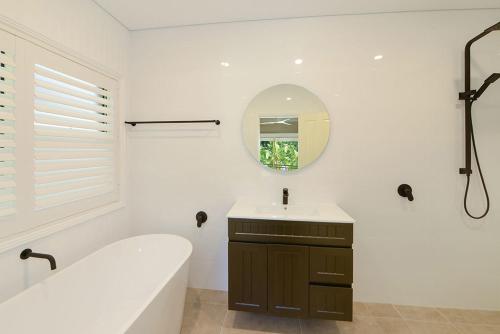 North AvocaThe Acreage Boutique Guesthouse的带浴缸、水槽和镜子的浴室