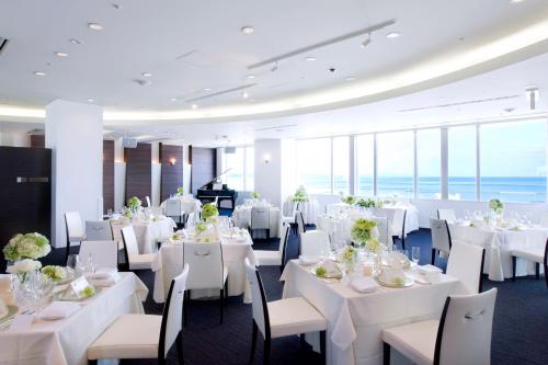 青森青森酒店的一间设有白色桌椅和窗户的用餐室