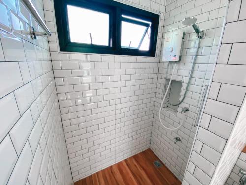 Ban Chalaengเดอนาปัว วิลล่า的浴室设有白色瓷砖淋浴和窗户。