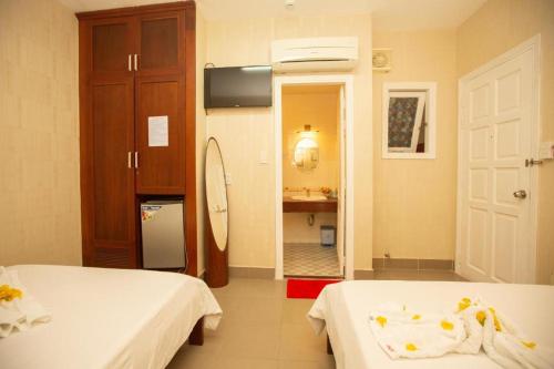 头顿HANZ Bao Khoi Hotel的一间带两张床的卧室和一间带水槽的浴室