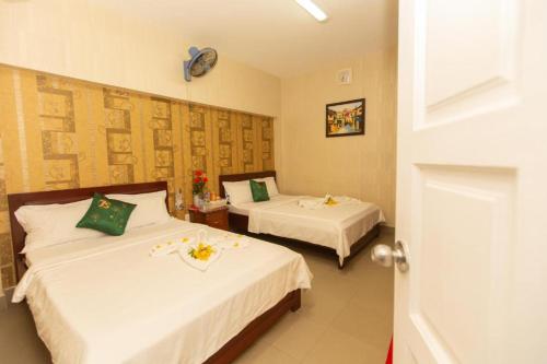 头顿HANZ Bao Khoi Hotel的酒店客房,配有两张带鲜花的床