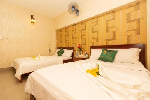 头顿HANZ Bao Khoi Hotel的一间卧室配有两张带白色床单的床