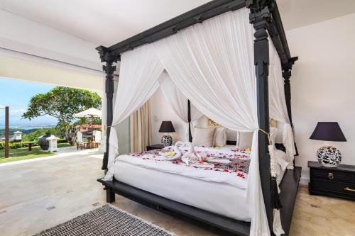 乌鲁瓦图Villa Puri Balangan的一间卧室设有一张天蓬床,享有美景。