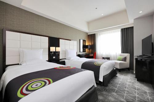 福冈福冈皇家花园酒店的酒店客房设有两张床和电视。