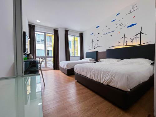 士姑来Cel Hotel的一间卧室设有两张床和一张风力涡轮机壁画