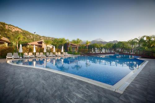 契拉勒Kimera - Akdeniz Bahcesi Apart Hotel的一个带椅子的大型游泳池,一个度假村