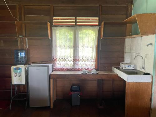 沙璜UKCC (Ujung Karang Conference Center)的厨房配有冰箱和窗户。