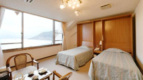 富士河口湖广隆酒店的酒店客房设有两张床和窗户。