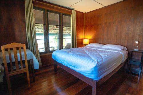 班武里府SeeSea Thai wooden house on beachfront的卧室配有床、椅子和窗户。