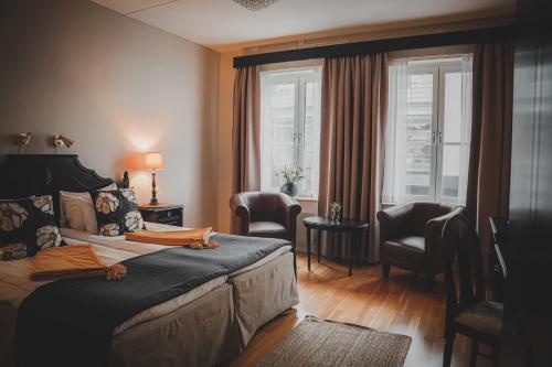 厄勒布鲁Mojo Hotell的一间卧室配有一张床、两把椅子和一个窗户