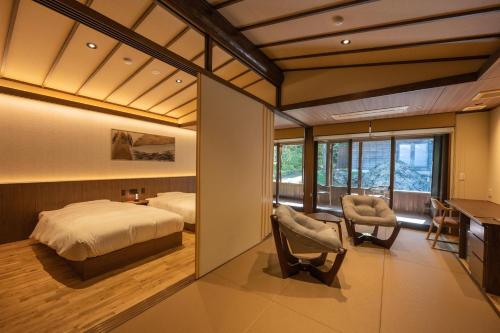 三条市嵐渓荘旅馆的卧室配有一张床、一张桌子和椅子