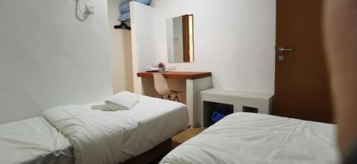 阿罗士打Tang Hotel的客房设有两张床、一张桌子和一面镜子。