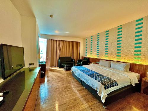 民都鲁New World Express Motel的配有一张床和一台平面电视的酒店客房